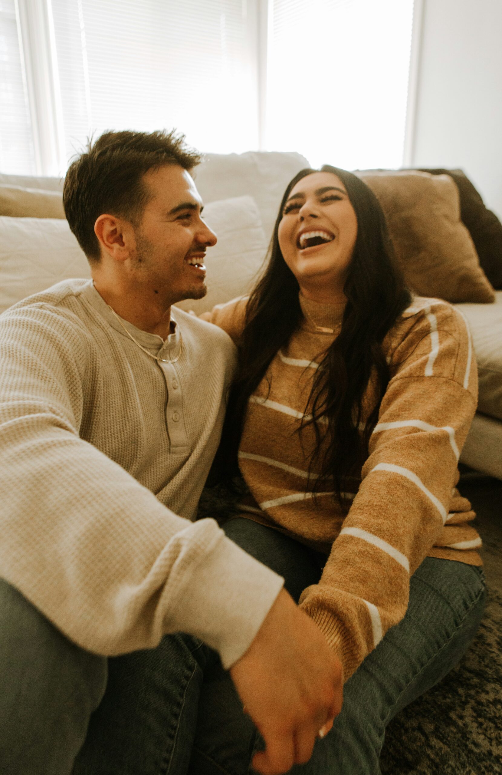 couple laughing together at home — marriage counseling in utah helps couples reconnect